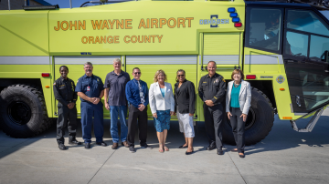 Members from the Orange County Fire Authority, John Wayne Airport, and Orange County Supervisor Katrina Foley stand in front of a new Crash 3 vehicle at Orange County Fire Station 33.