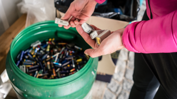 Batteries Being Disposed of in Recycling Center, hands of a woman