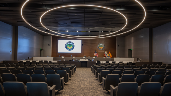 a conference room with rows of chairs and a projection screen