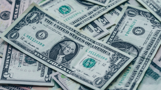 a pile of one hundred dollar bills sitting on top of each other