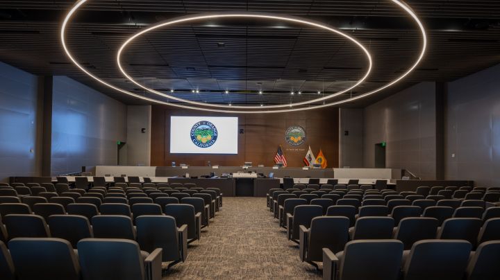 a conference room with rows of chairs and a projection screen