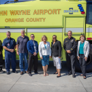 Members from the Orange County Fire Authority, John Wayne Airport, and Orange County Supervisor Katrina Foley stand in front of a new Crash 3 vehicle at Orange County Fire Station 33.