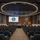 a conference room with rows of chairs and a projection screen