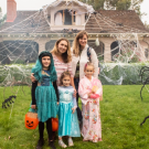 a family poses for a photo in front of a house decorated for halloween