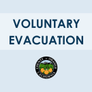 The image contains a message that reads "VOLUNTARY EVACUATION" in bold, dark blue capital letters against a light blue gradient background. Below the text, there is the official seal of Orange County, California.