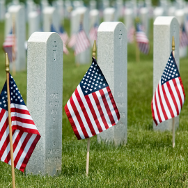 a row of flags in a cemetery