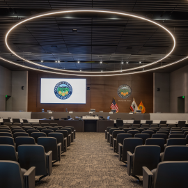 a conference room with rows of chairs and a projection screen