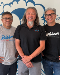 Wing Lam and the Lee Family, Orange County Hall of Fame Inductee, Class of 2024, Wing Lam and his two brothers standing inside a Wahoo's Fish Taco establishment