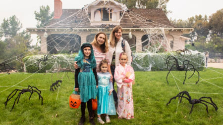 a family poses for a photo in front of a house decorated for halloween