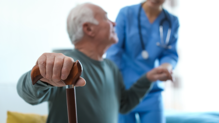 Care Worker Helping Elderly Man in Geriatric Hospice